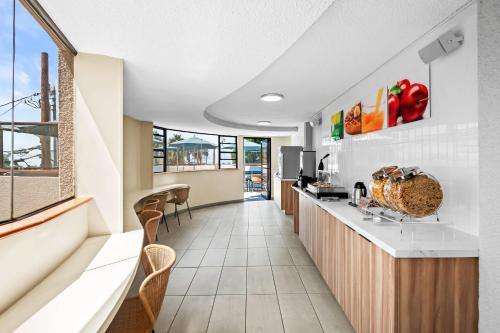 a kitchen with a counter and chairs in a building at Quality Inn & Suites Hermosa Beach in Hermosa Beach