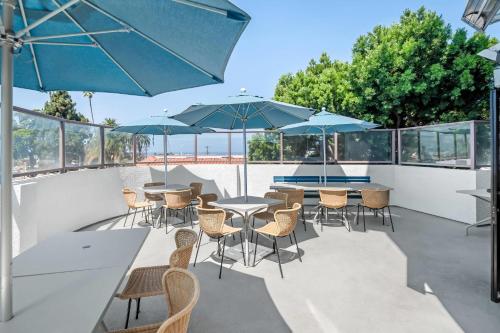 a patio with tables and chairs and umbrellas at Quality Inn & Suites Hermosa Beach in Hermosa Beach