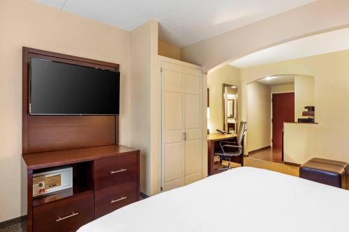 a hotel room with a bed and a flat screen tv at Comfort Suites near Penn State - State College, PA in State College