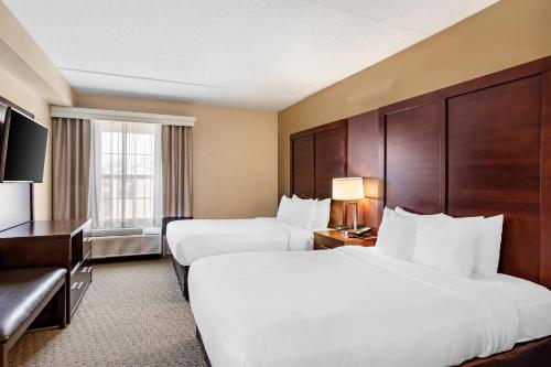 a hotel room with two beds and a television at Comfort Suites near Penn State - State College, PA in State College