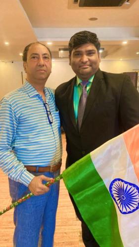 two men standing next to each other holding a flag at Presidency Landmark in Daman