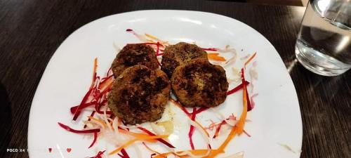 a white plate with three pieces of food on it at Presidency Landmark in Daman