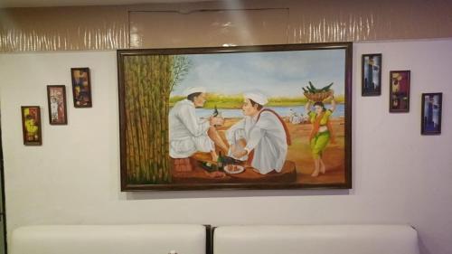 a painting on a wall of a painting of two priests at Presidency Landmark in Daman