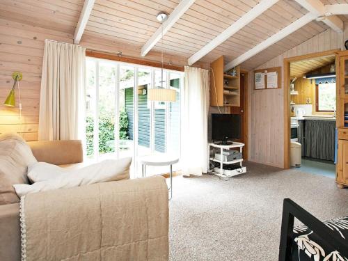 a living room with a couch and a tv at 6 person holiday home in Dannemare in Dannemare