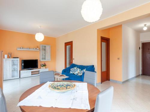 a living room with a table and a blue couch at Etna & Sea View Apartment in Giarre