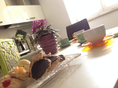 a table with a plate of pastries and coffee cups at Sweet Holiday Home in Bernalda