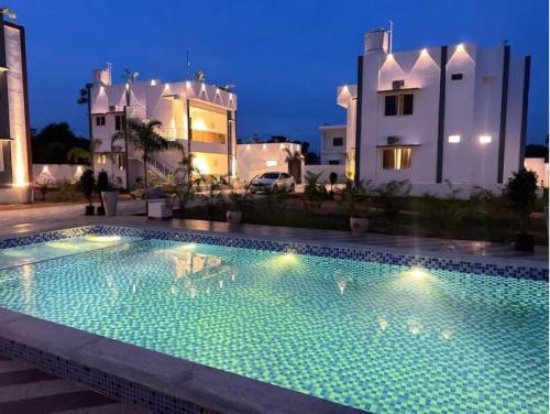 a swimming pool in front of a building at night at Le Park Luxury Resort - TIE Hotels & Resorts in Puducherry