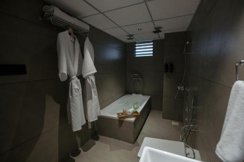 a bathroom with a bath tub and a sink at Biznotel by Pride Surat in Surat