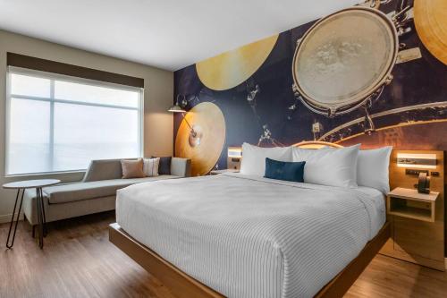 a bedroom with a large bed and a couch at Cambria Hotel Austin Airport in Austin