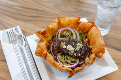a sandwich on a white plate on a table at Cambria Hotel Austin Airport in Austin