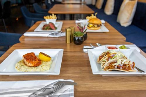 a wooden table with plates of food on it at Cambria Hotel Austin Airport in Austin