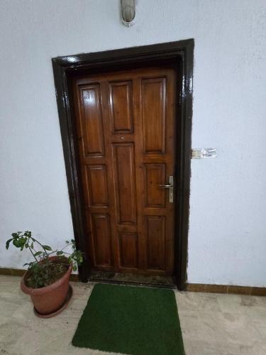 a wooden door with a green mat in front of it at Deluxe Furnished Studio Jubaiha in Amman