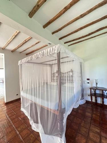 a bedroom with a bed with a mosquito net at Glamorous Getaway PM in Malindi