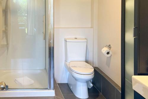 a bathroom with a toilet and a shower at Quality Inn Acapulco Taupo in Taupo