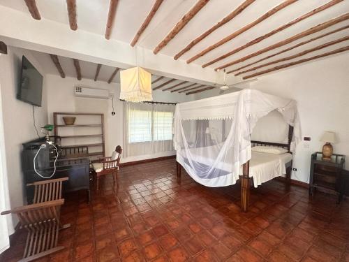a bedroom with a bed with a mosquito net at Glamorous Getaway PM in Malindi