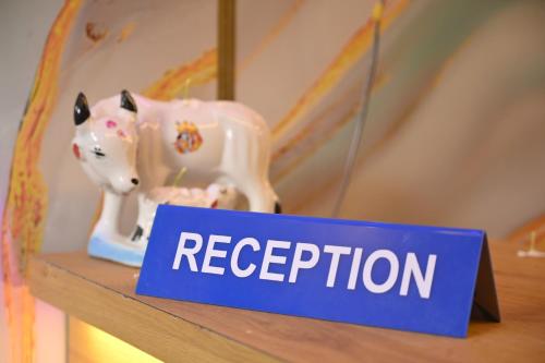 a toy cow on a shelf with a registration sign at Sai Padma Guest House in Konārka