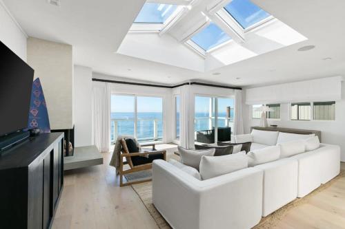 a living room with a white couch and windows at Playa Del Sol by Stay Awhile Villas in Malibu