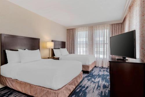 a hotel room with two beds and a flat screen tv at The Connally Hotel Downtown Atlanta, an Ascend Collection Hotel in Atlanta