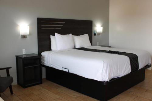 a bedroom with a large bed with a black headboard at Rodeway Inn Yuma Downtown in Yuma