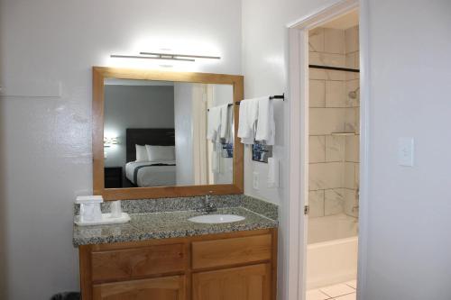 a bathroom with a sink and a mirror at Rodeway Inn Yuma Downtown in Yuma