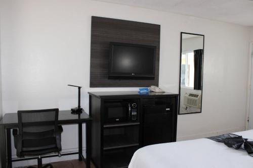 a bedroom with a desk and a tv and a chair at Rodeway Inn Yuma Downtown in Yuma