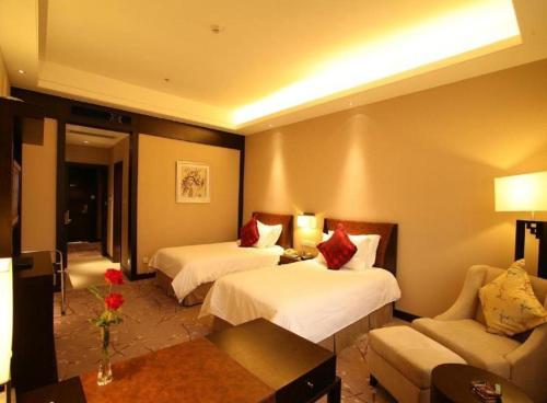 a hotel room with two beds and a couch at Jin Jiang Nanjing Hotel in Nanjing