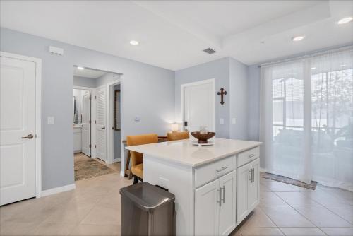 una cocina con una isla blanca en una habitación en GRH14800 - Charlotte County - 2 Bed 2 Baths Condo, en Tropical Gulf Acres