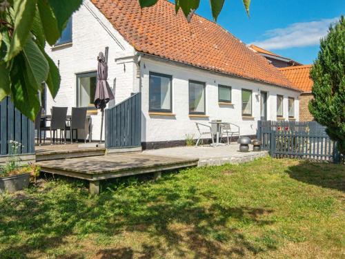 a white house with a bench and a table at Enchanting Cottage in Oksbol Oasis-By Traum in Nordborg