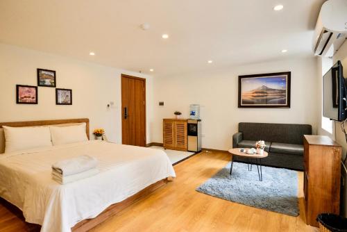 a bedroom with a bed and a couch and a television at happy house 2 in Lóc Ða