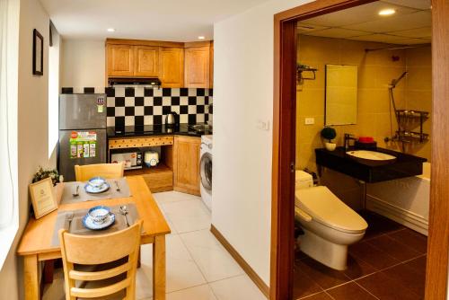 a kitchen with a table and a toilet and a sink at happy house 2 in Lóc Ða