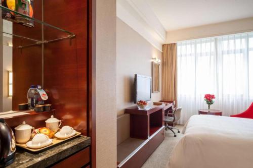 a hotel room with a bed with a tray of food at Best Western Plus Fuzhou Fortune Hotel in Fuzhou