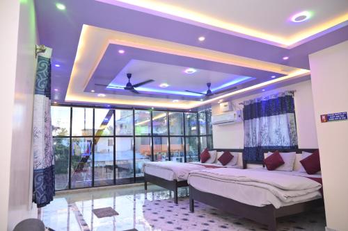 a room with three beds and a large window at Sai Padma Guest House in Konārka