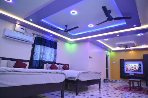 a room with two beds and a tv in it at Sai Padma Guest House in Konārka