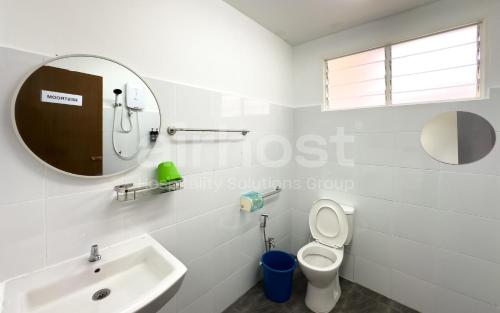 a white bathroom with a sink and a mirror at Family Home Ampang Utama with Swimming Pool in Ampang