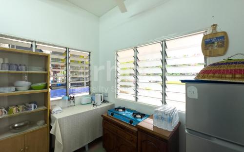 a kitchen with a counter and a refrigerator andwindows at Family Home Ampang Utama with Swimming Pool in Ampang