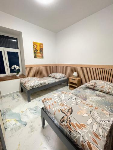 a bedroom with two beds and a window at PENZION Hamburk in Beroun