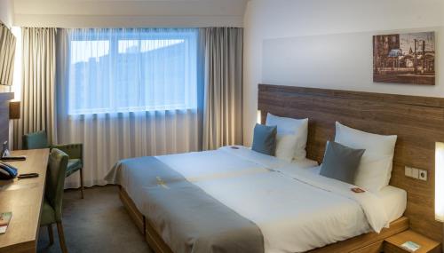 a hotel room with a large bed with a window at Hotel Stadtpalais in Cologne