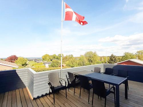a flag on a deck with a table and chairs at 10 person holiday home in Roslev in Flovtrup