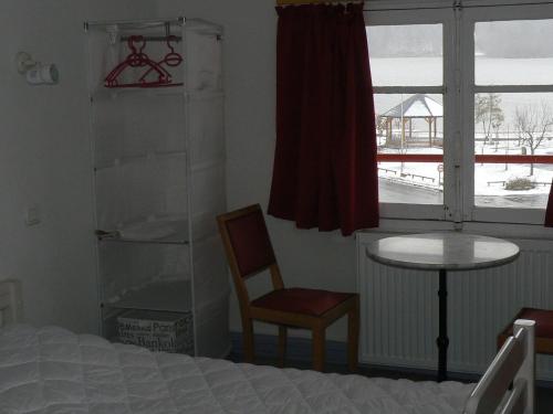 um quarto com uma cama, uma mesa e uma janela em La Vue sur le Paradis em Chambon-sur-Lac