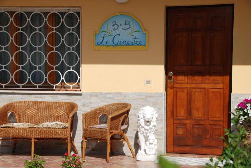 a building with two chairs and a door at B&B Le Ginestre in Collestrada