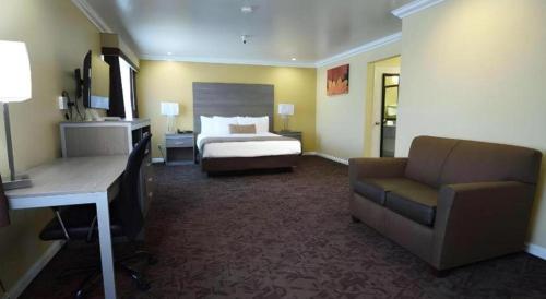 a hotel room with a bed and a desk and a couch at Best Western Hanford Inn in Hanford
