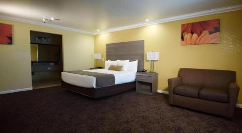 a hotel room with a bed and a couch at Best Western Hanford Inn in Hanford