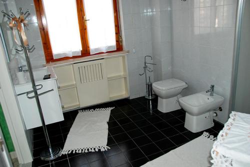 a white bathroom with a toilet and a sink at B&B Le Ginestre in Collestrada