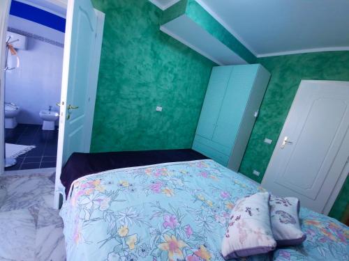 a bedroom with a bed and green walls at B&B Le Ginestre in Collestrada