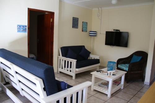 a room with a crib and a chair and a table at 28 Kabeljauws in Jeffreys Bay
