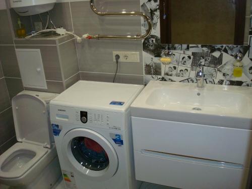 a bathroom with a washing machine and a sink at Apartment on Privokzalnaya 2/1 in Vinnytsya