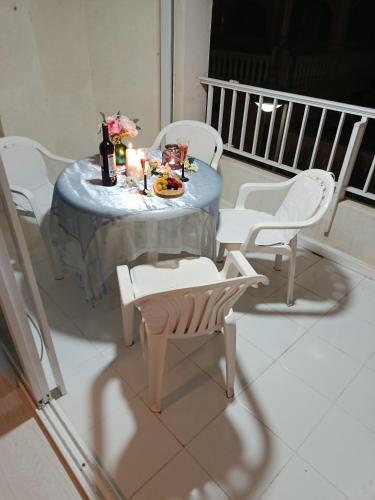 a table with white chairs and a table with food on it at BRISA DEL MAR en primera línea in Torres-Torres