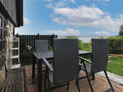 a table and chairs on a patio with a view of the ocean at Seaside Escape in Hindsholm - By Traum Ferienwohnungen in Mesinge