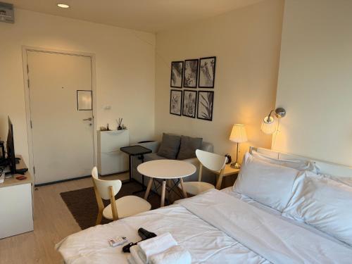 ein Schlafzimmer mit einem Bett, einem Tisch und einer Couch in der Unterkunft Cozy5Living in Bangkok 60m to MRT near chatuchank in Ban Bang Khwang