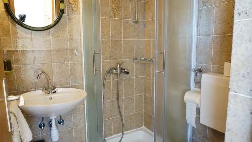 W łazience znajduje się umywalka i prysznic. w obiekcie Guesthouse Garni w mieście Stara Novalja